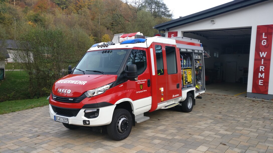 Feuerwehrfahrzeug mit Einsatzkräften und Jugendlichen
